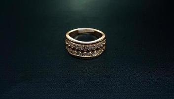 Photo of womens gold ring on a black background
