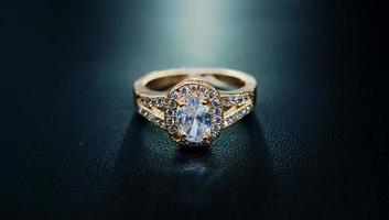 Photo of womens gold ring decorated with a sparkling diamond