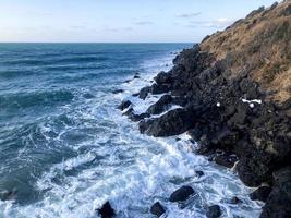 Solidified lava near water of sea in Jeju island. South Korea photo