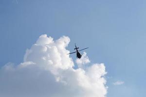 On the azure sky, a helicopter flies. photo