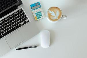 Top view mock up smartphone with mouse computer laptop and pen and coffee, calculator.Copy space flat lay. photo