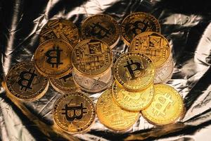 monedas criptográficas y bitcoins colocados en un tablero plateado foto