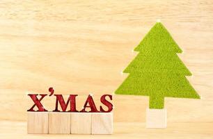 Palabra de Navidad roja con árbol de Navidad verde en sala de madera foto