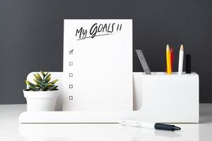My goals list on notepad at modern office stationery on white table photo