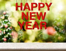 Happy new year red wood word hanging over marble table top photo
