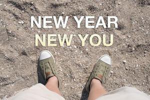 Aerial view of New year New you word on sand with people foot photo