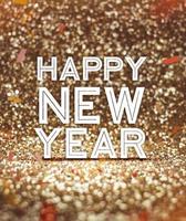 Feliz año nuevo palabra en fondo de brillo dorado brillante con confeti foto