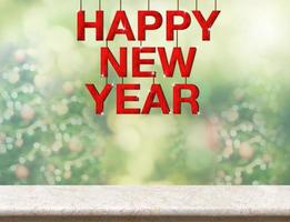 Red happy new year wood word hanging over marble table photo