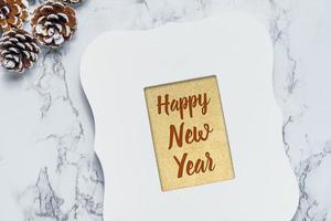 Feliz año nuevo texto en fondo dorado brillo en marco de fotos blanco vintage