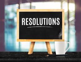Resolutions word on Blackboard with easel on brown black marble table photo