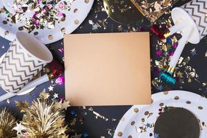 tarjeta de felicitación dorada en blanco con copa de fiesta, soplador de fiesta, oropel, confeti. foto