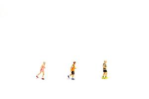 Miniature people running on white background photo