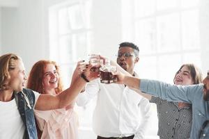 para el futuro. compañeros de equipo bebiendo whisky y riendo por un trato exitoso foto