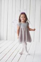 Photo in full height. Beautiful little girl with fairy costume having fun posing for the pictures