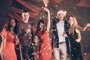 Air in the confetti. Five good friends in the good clothes are on the party of new year photo