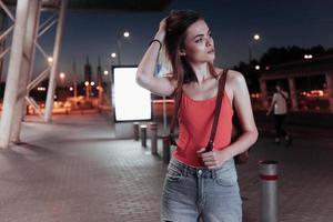 Traveling conception. Attractive woman fixes her hair with her hand and looking on the road photo