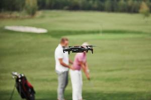 Group of stylish friends on the golf course learn to play a new game photo