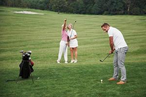 Group of stylish friends on the golf course learn to play a new game photo