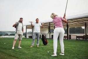 Group of stylish friends on the golf course learn to play a new game photo