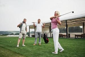 grupo de elegantes amigos en el campo de golf aprende a jugar un nuevo juego foto
