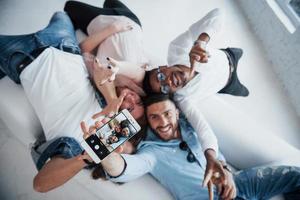 Young people laying down and take a selfie with focus on the phone photo