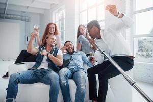 Afro american guy make a good job by creating good mood. Friends decides to relax by singing their favourite songs photo