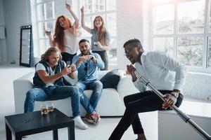 Awesome afro american guy in the front of people start the crowd. Friends decides to relax by singing their favourite songs photo