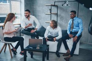 Discussion in active. Group of multiracial office workers in formal clothes talking about tasks and plans photo