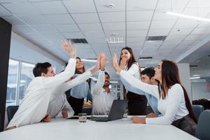 Congratulating each other. Job is done. Group of office workers happy to hit their own records and being successful photo