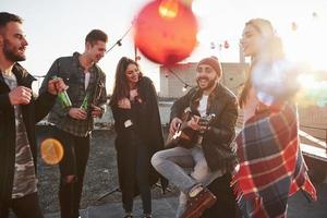 Decorative accessories. Rooftop party with alcohol and acoustic guitar at sunny autumn day