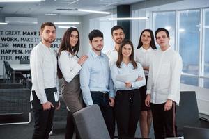 Portrait of young team in classical clothes in the modern good lighted office photo