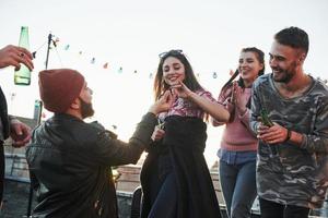 Sea amable con el anillo. declaración de amor en la azotea con compañía de amigos foto