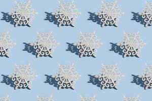 Pattern of wood snowflakes on a blue background Cristmas New year minimalistic concept photo