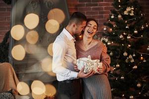 New year happiness. Christmas gift for the woman. Gentleman in classic suit gives his wife the present