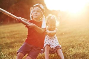 luchando. no te rindas. esto es tira y afloja con papá en la hermosa hierba de un día cálido y soleado foto