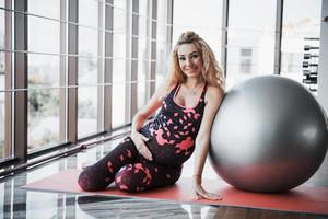 Young pregnant woman sitting and holding a bullet for exercises