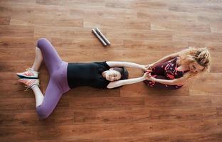 Pregnant woman doing yoga with personal trainer. photo