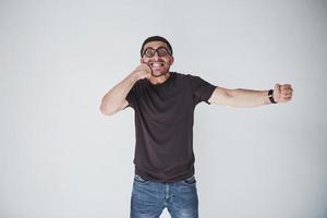 A young man in casual clothes on the background struck himself on the fist in the face. The concept of self-punishment for their own mistakes photo