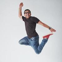 Image of cheerful young man casual dressed jumping over white background make different gesture photo