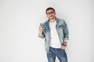 Young handsome male business executive in casual attire holding a credit card in the pockets on a white background. The concept of trading on the Internet and the ease of electronic money photo