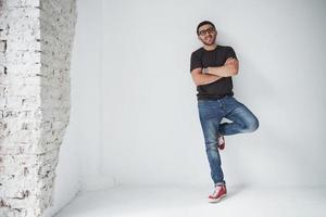 Young hipster guy wearing glasses laughing happily isolated on white background photo