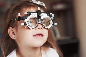 Close up portrait of child in special glasses that watching to the right photo
