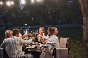 Family weekend. Evening time. Friends have a dinner in the gorgeous outdoor place photo