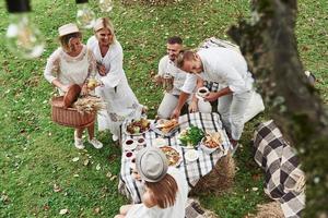 Everyone is satisfied. Top view of five good friends have a dinner and conversation outdoors photo