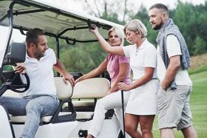 vamos a dar una vuelta. sentado en el carrito de golf después del juego foto