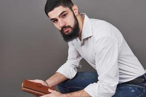 Portrait of toothy handsome bearded man with book on hands photo