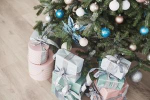 Christmas tree with wooden rustic decorations and presents under it in loft interior photo