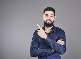Cheerful handsome man showing direction and pointing with finger