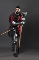 caballero medieval sobre fondo gris. retrato, de, brutal, cara sucia, guerrero, con, cota de malla, armadura, rojo, y, negro, ropa, y, batalla, hacha