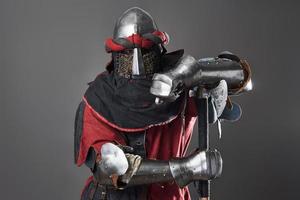 caballero medieval sobre fondo gris. retrato, de, brutal, cara sucia, guerrero, con, cota de malla, armadura, rojo, y, negro, ropa, y, batalla, hacha
